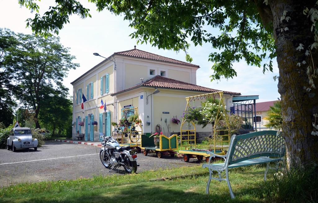 une maison avec une moto garée devant elle dans l'établissement Avenue de la Gare, à Riscle