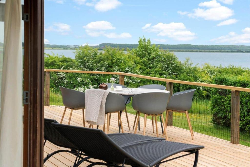 a table and chairs on a deck with a view of the water at 30725-Odder-Skovgardsparken-87 in Odder