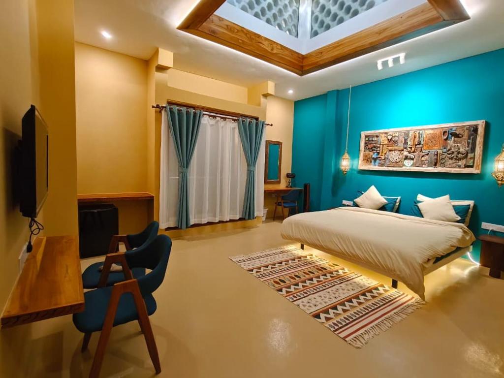 a bedroom with a bed and a blue wall at The Swahili Plaza in Matemwe