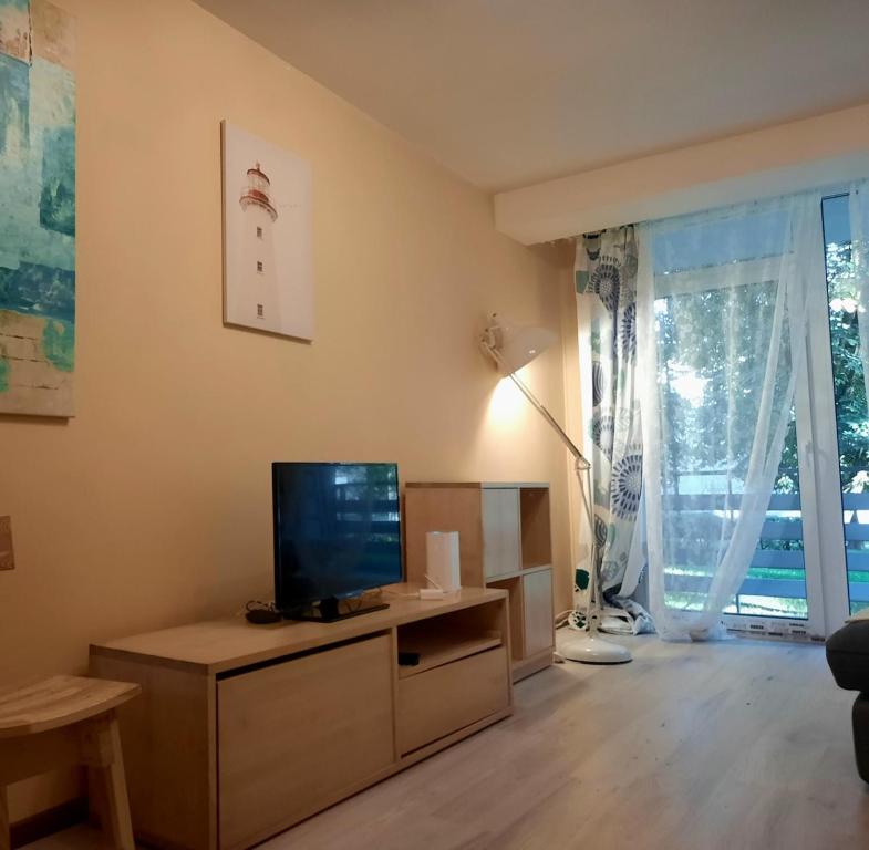 a living room with a flat screen tv on a table at Cozy 2-Bedroom flat with Terrace & Parking by Alfa in Rīga