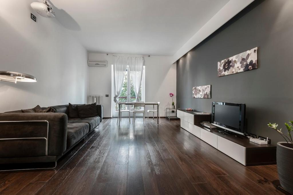 un soggiorno con un divano e una televisione di Quite and Bright Tortona District a Milano