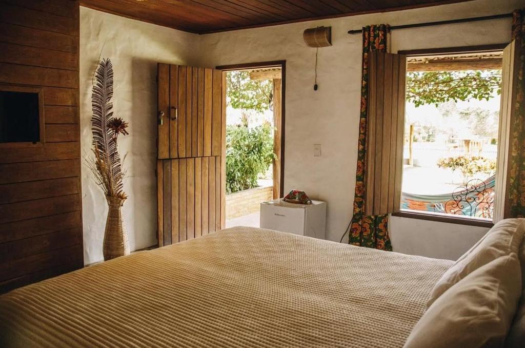 une chambre avec un lit et une grande fenêtre dans l'établissement Pousada Villa Morena, à Porto de Pedras