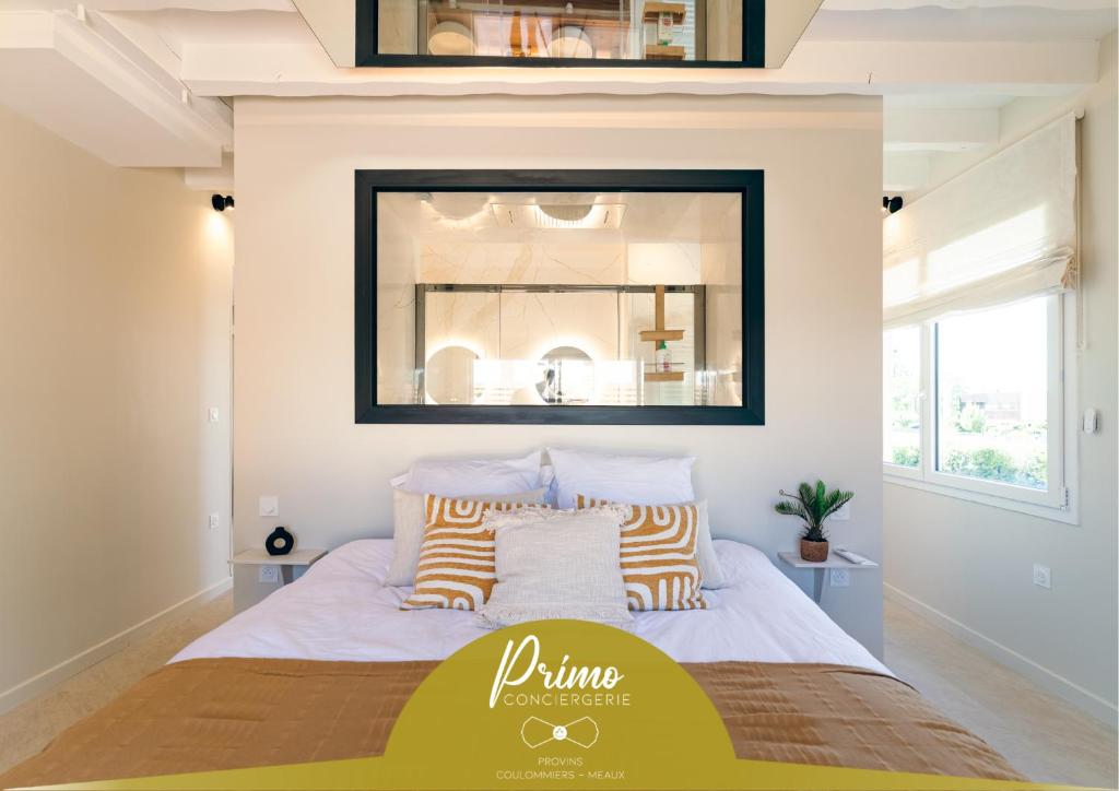Un dormitorio con una cama con un espejo encima. en La Bali, Luxe et relaxation, en La Ferté-Gaucher