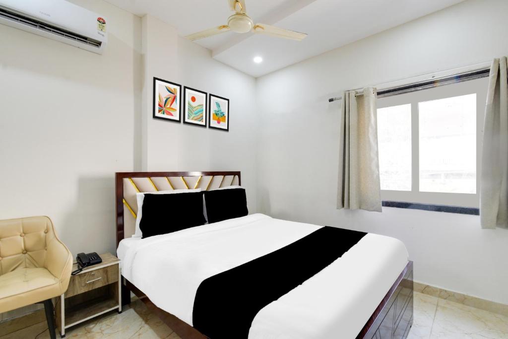 a bedroom with a bed and a chair and a window at Hotel O Skyline in Surūrnagar