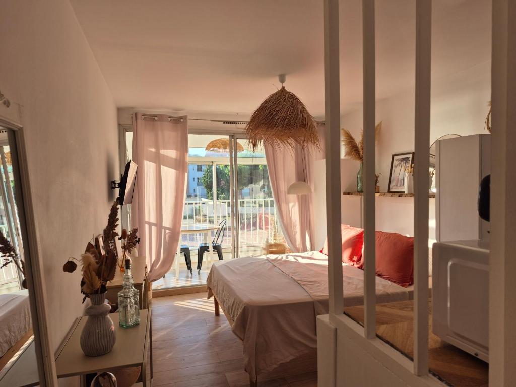 カップ・ダグドにあるAGREABLE STUDIO VUE PORT AU CAP D'AGDEのベッドとバルコニーのある寝室