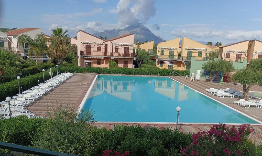 a large swimming pool with a mountain in the background at Villaggio 101 Pini in Buonfornello