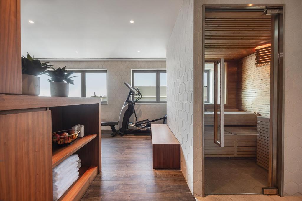 A compact fitness area beside a glass-fronted sauna.