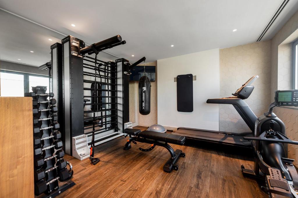 A bright hotel gym with cardio and strength-training equipment.