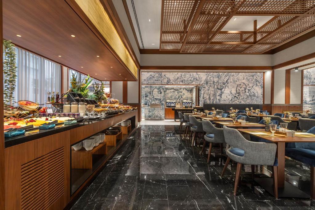 A breakfast room with a long buffet display and indoor dining tables.