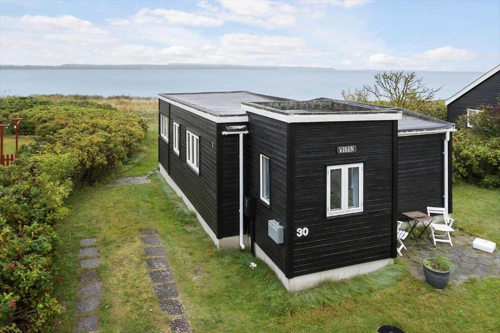 a black tiny house sitting on top of a yard at 40161-Juelsminde-Bugten-30 in Juelsminde
