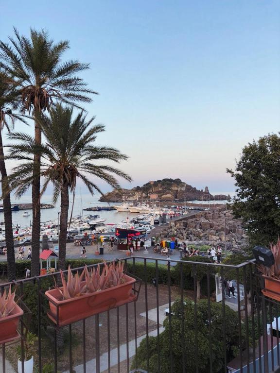 - une vue sur une plage avec des palmiers et un port dans l'établissement Mythos Home, à Aci Castello