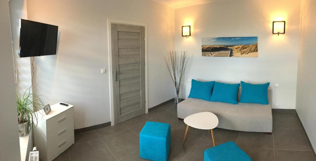 a living room with a couch and blue pillows at Panorama Gdynia Rooms in Gdynia