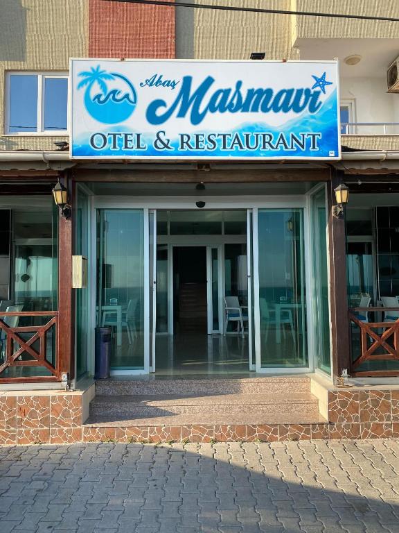 a building with a sign for a restaurant at Abaş Masmavi Otel in Yumurtalık