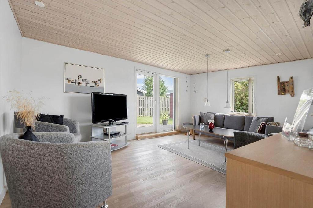 a living room with a couch and a tv at 40152-Juelsminde-Mirabellevej-5 in Juelsminde