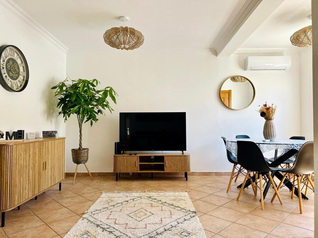 a living room with a television and a table at Casa Esperança in Albufeira