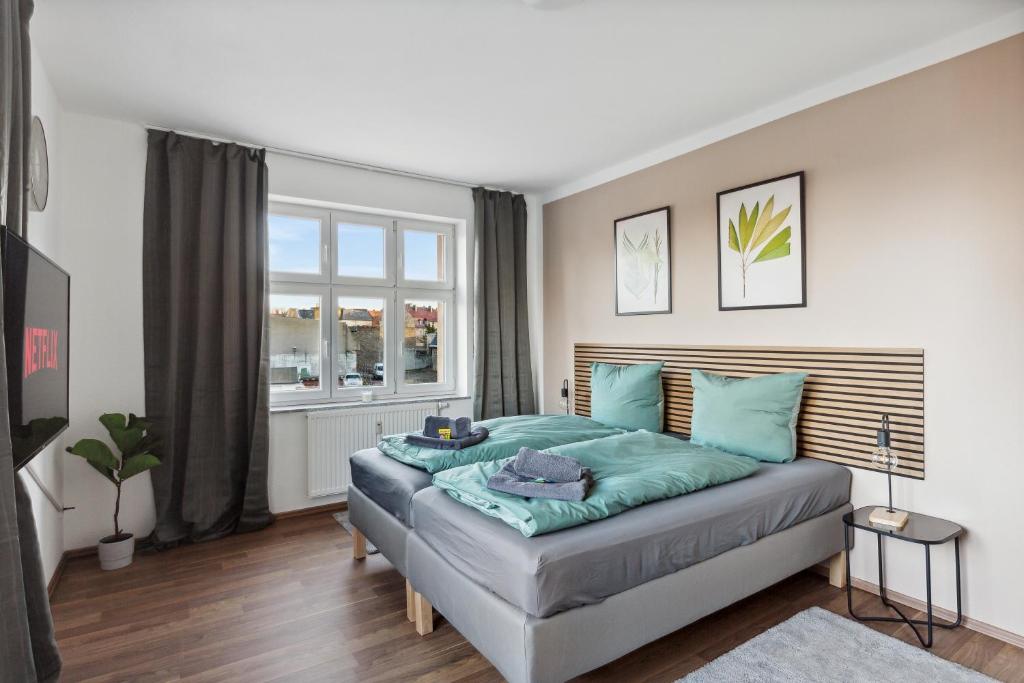 a bedroom with a large bed with blue pillows at Aura - Nulandt#3 - 2 Zimmer, 4 Betten, Küche, Balkon, Waschmaschine in Merseburg