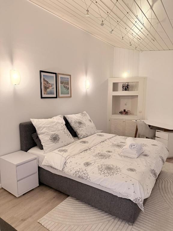 a white bedroom with a large bed in it at Bungalow sunshine in Weilerswist