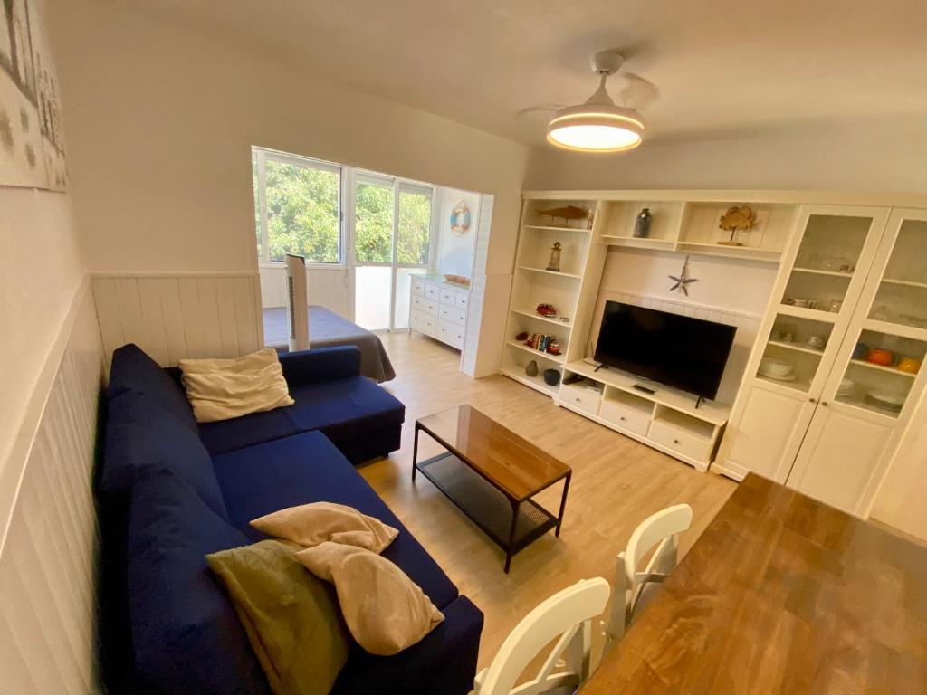 a living room with a blue couch and a table at Loft playa Torviscas,garaje gratis , recién reformado in Adeje
