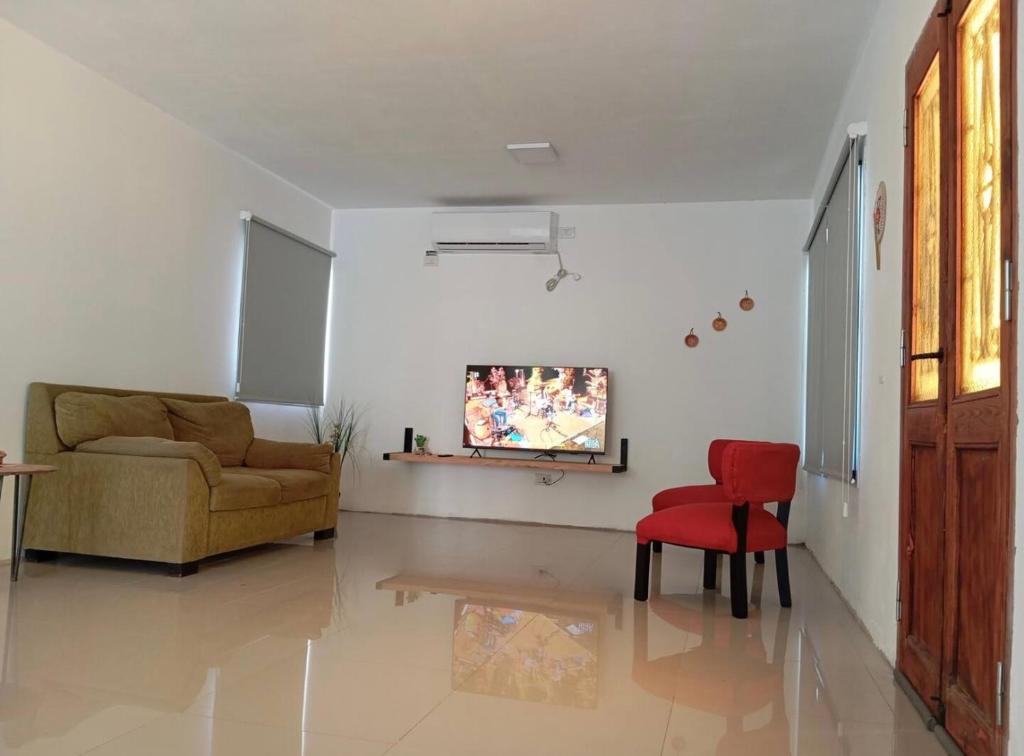 a living room with a couch and a red chair at Gladis apartment in Arequipa