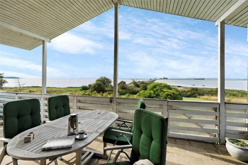 a patio with a table and chairs and a view of the ocean at 30711-Odder-Skovgardsparken-1 in Odder