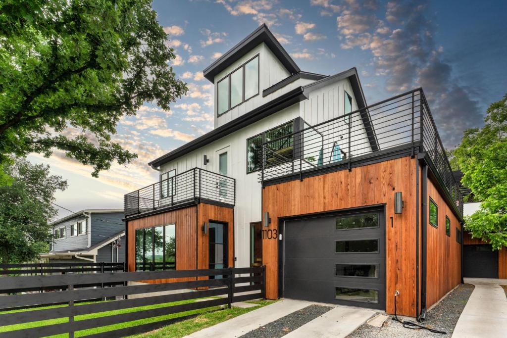 a large white house with a garage at Luxe Riverside Condo in Austin