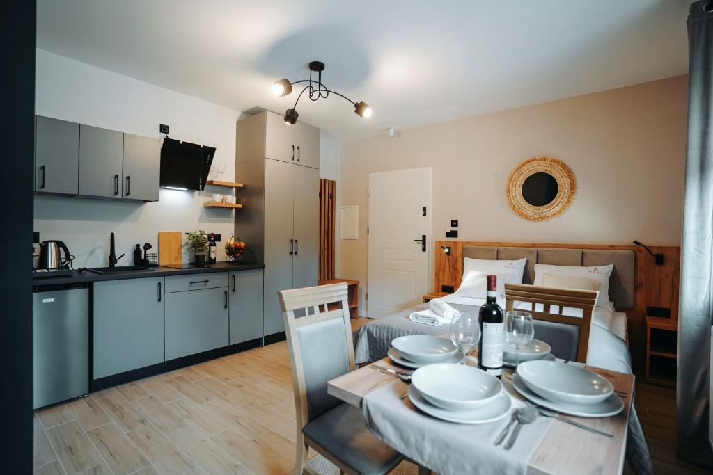 a kitchen and a bedroom with a table and a bed at Althea Ustrzyki Apartments in Ustrzyki Dolne