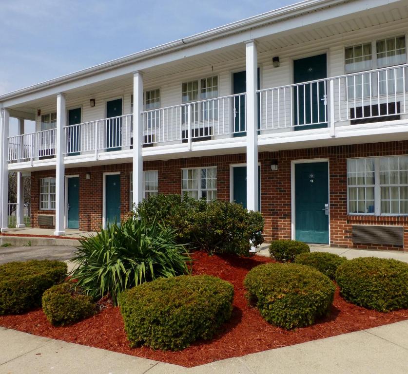 an apartment building with bushes in front of it at Deerfield Inn in Xenia