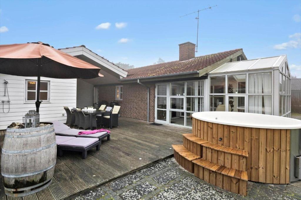a backyard with a hot tub and a house at 40154-Juelsminde-Nattergalevej-10 in Juelsminde