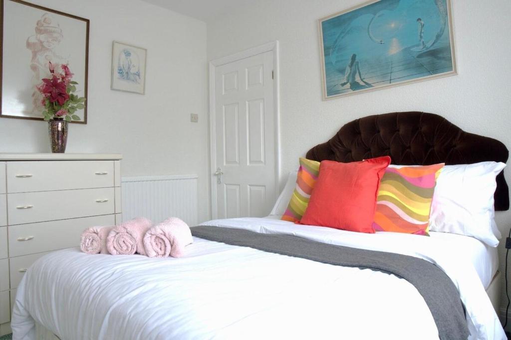 a bedroom with a bed with pink towels on it at Traditional 3-Bedroom Home- contractors and family in Dartford