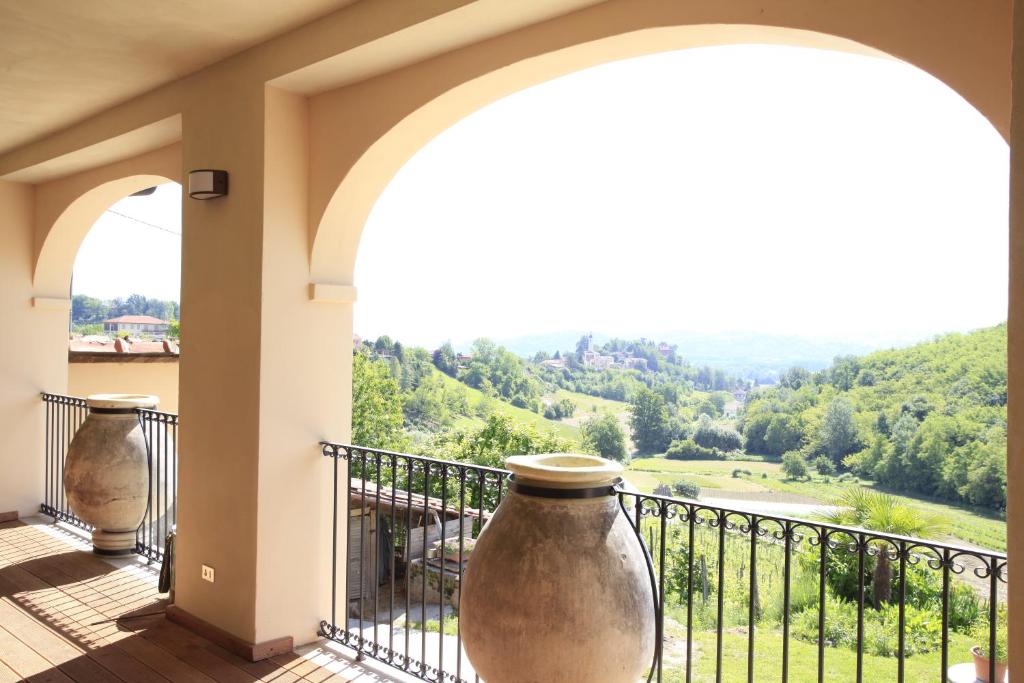 a balcony with two large vases on a railing at Al Canei B&B in Asti