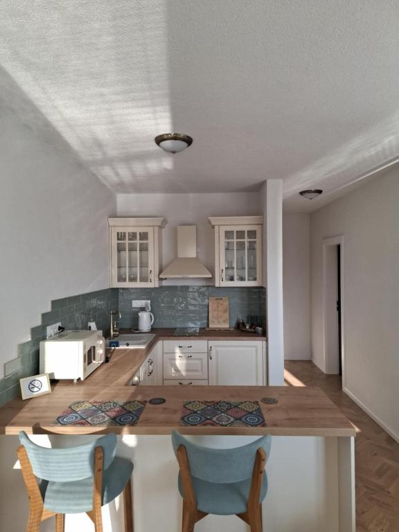 a kitchen with white cabinets and a table and chairs at Apartman JAMI in Spišské Podhradie