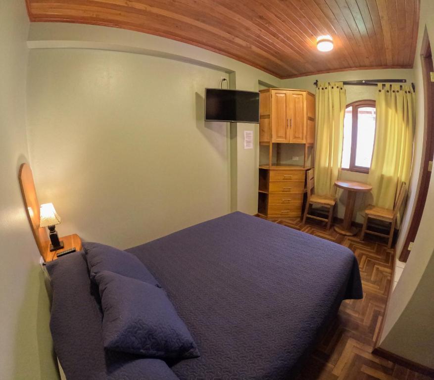 a bedroom with a blue bed in a room at Rajutuna Inn in Huaraz