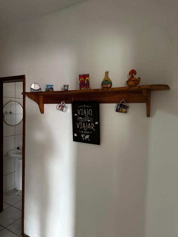 a shelf on a wall with a sign on it at Taba House in São Gabriel