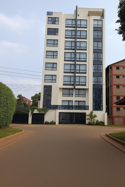 a tall white building with a street in front of it at Executive Studio in Kinoo in Rungiri