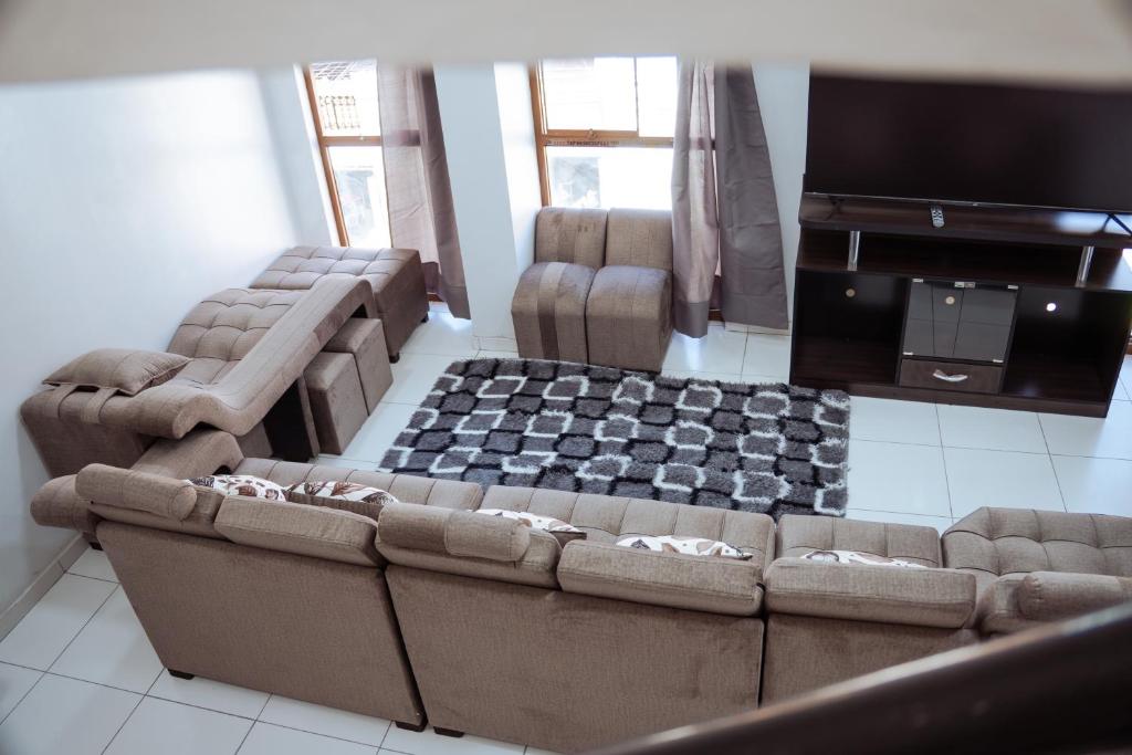 a living room with two couches and a flat screen tv at duplex acogedor in Cusco