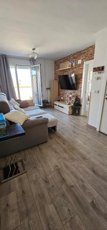a large living room with a couch and a television at Ático con Terraza Feria Albacete in Albacete