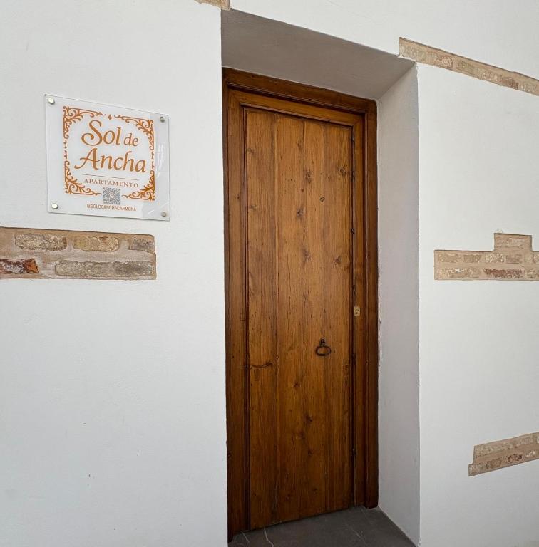 a wooden door in a white room with a sign at Sol de Ancha in Carmona
