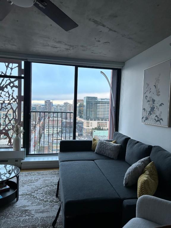 a living room with a couch and a large window at Cozy Gastown condo with a view! in Vancouver
