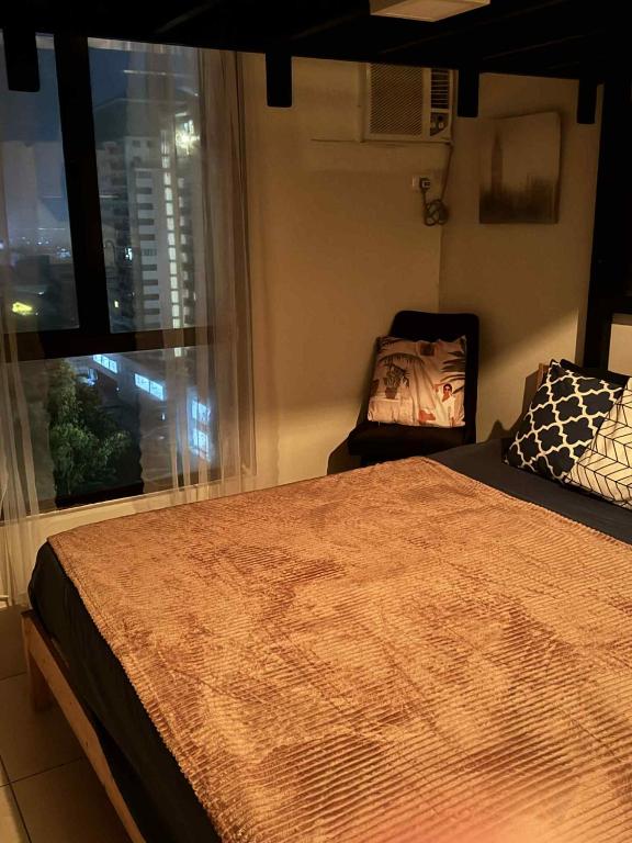 a bedroom with a large bed and a window at Tagaytay Staycation with Great Location in Tagaytay