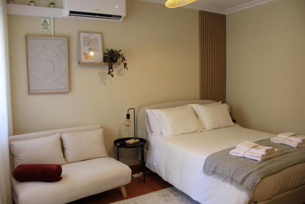 a bedroom with two beds and a couch at Carmo guestroom in Tabuaço
