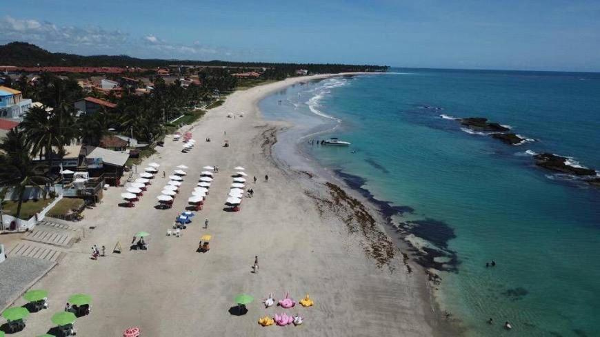 an overhead view of a beach with people and umbrellas at Apart Hotel Marinas Tamandaré - apt 304 in Tamandaré