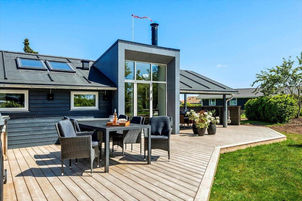 a deck with a table and chairs on a house at 30156-Odder-Chr-Christensensvej-4 in Beder