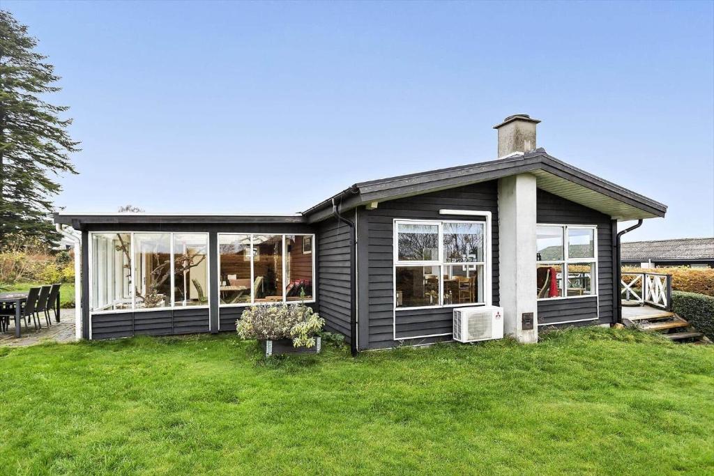 uma casa preta em um quintal com um campo de grama em 30462-Odder-Kirkeager-7 em Odder