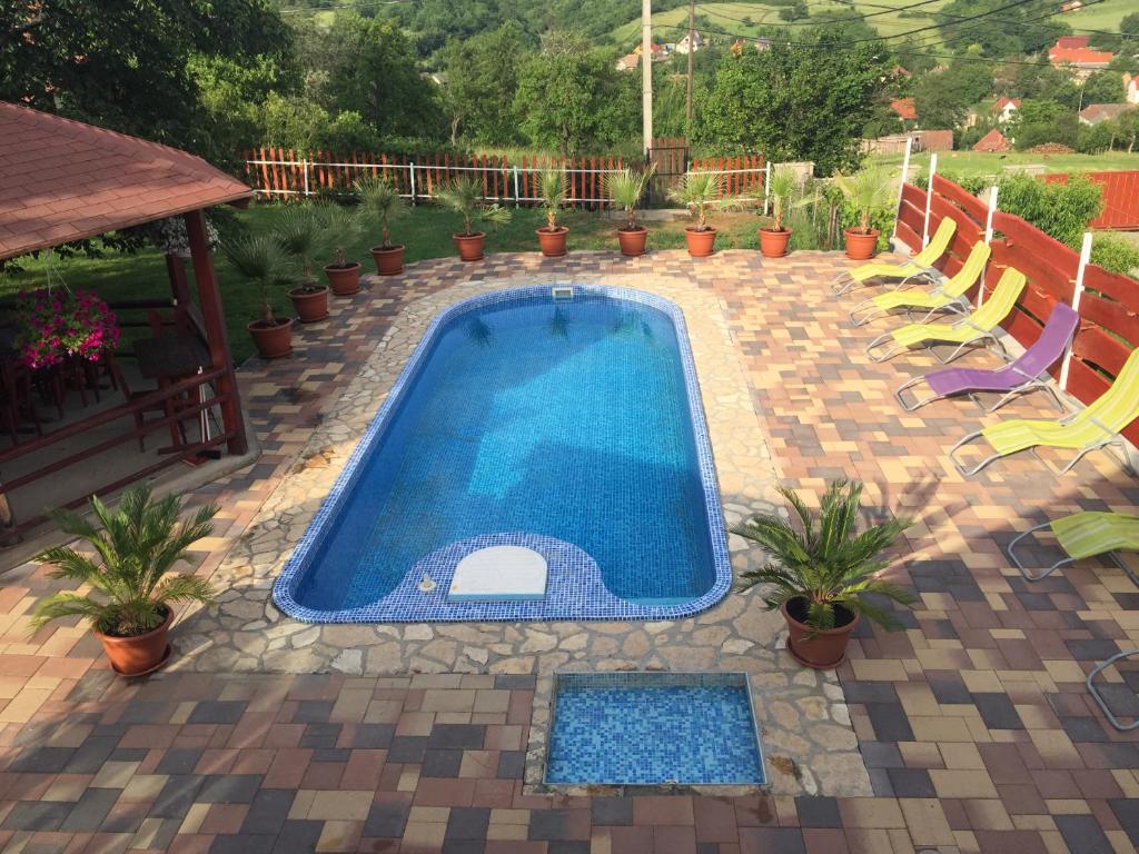 einen Pool auf einer Terrasse mit Stühlen und Pflanzen in der Unterkunft Sárvári Vendégház Pécs,Hosszúhetény in Hosszúhétény-Szőlőhegy