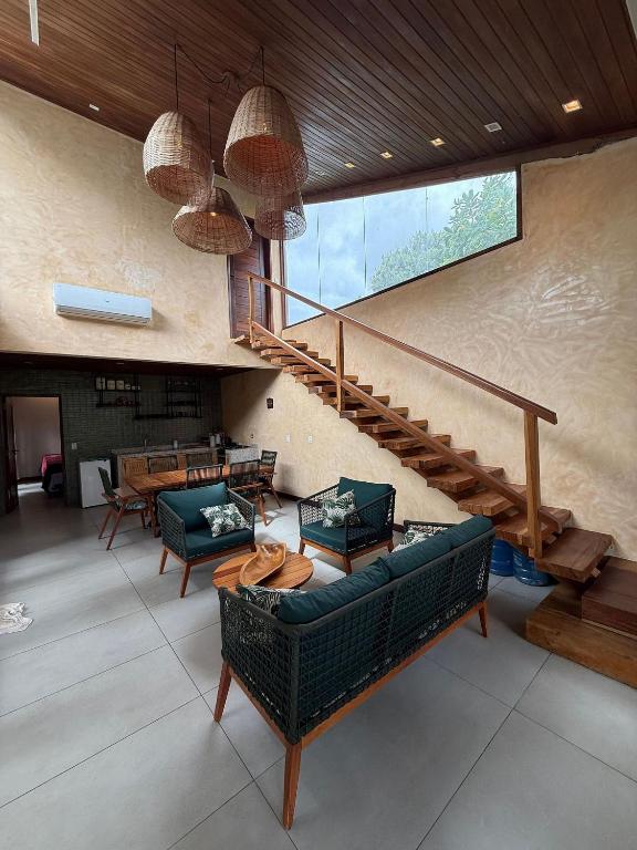 a living room with couches and a staircase at Chalé Iracema – Atins-MA in Atins