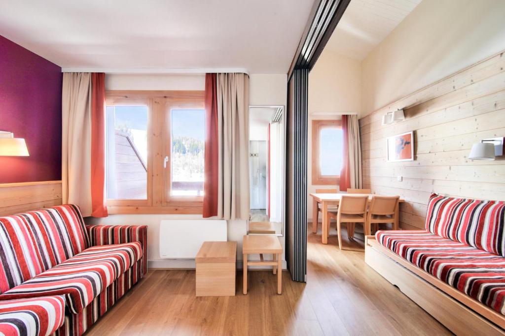 Una sala de estar con dos sofás y una mesa. en Résidence Plagne Lauze - maeva Home - Studio 4 personnes avec parking - Sélection MAE-2893, en Plagne 1800