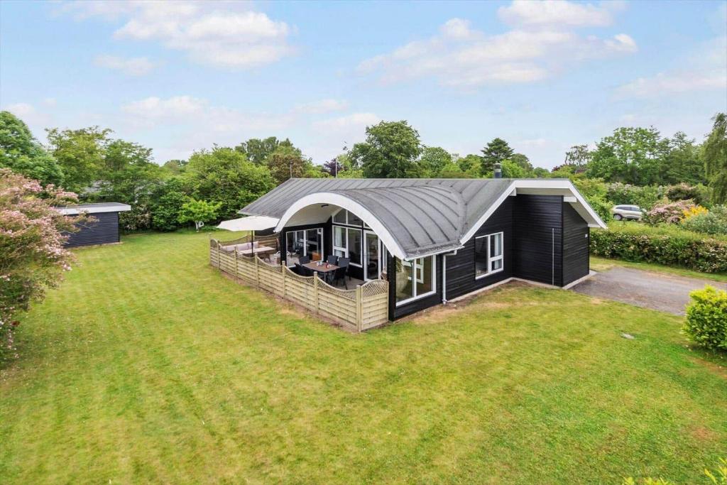 una casa nera con un tetto grigio su un cortile di 30523-Odder-Lillemosevej-24 a Odder