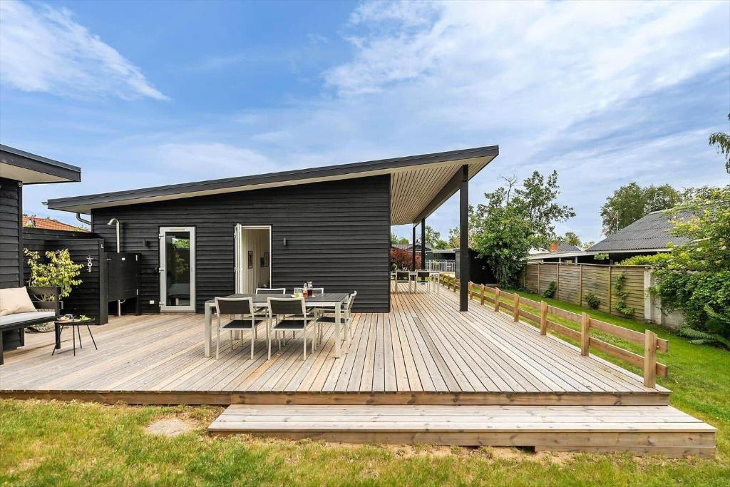 a wooden deck with a table and chairs on it at 40171-Juelsminde-Poppelalle-29 in Juelsminde