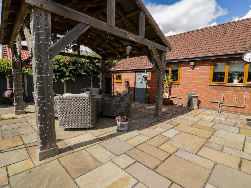 an outdoor patio with a wooden pergola at Pentre Country Studio in Trevor