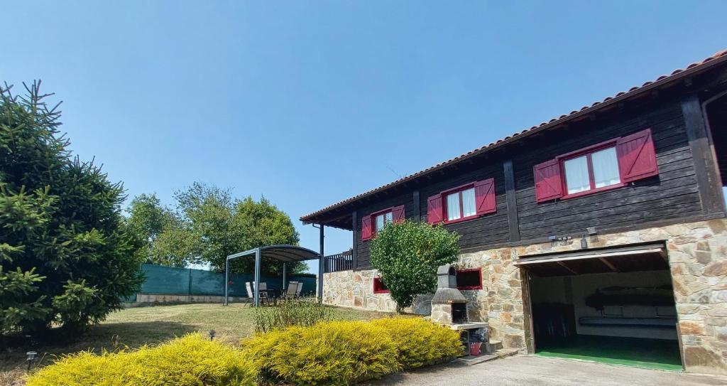 a barn with red windows and a garage at Olivar 51 in Villaviciosa